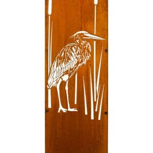 A heron standing in the grass on top of a wooden board.