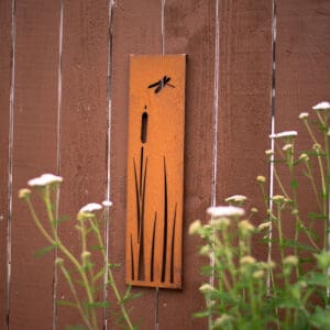 A wooden sign with a cattail and dragonfly on it.