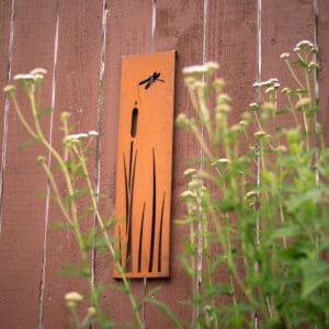A wall mounted clock with a dragonfly on it.