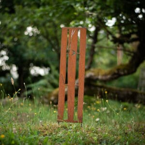 A wooden stick in the middle of some grass