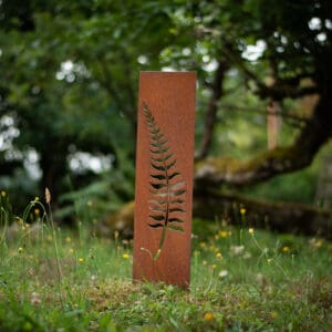 A fern sign in the middle of a field.