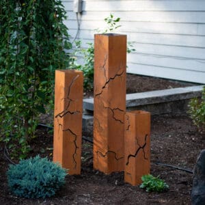 A group of three wooden posts in the ground.