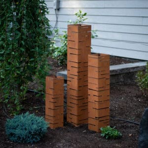 A group of bricks in the ground next to some bushes