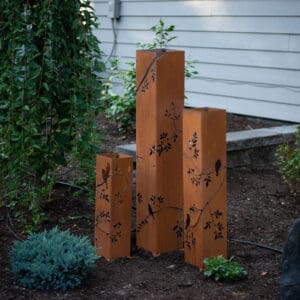 Rust-colored metal garden lantern pillars with cutouts